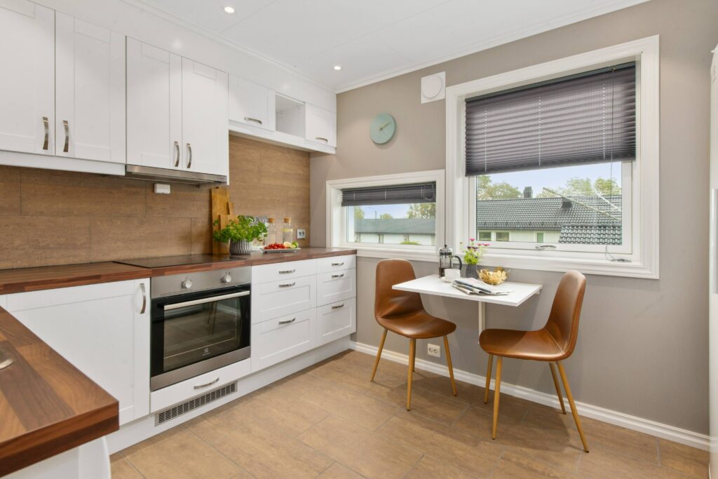 Kitchen with large windows showcasing a small coffee table. 