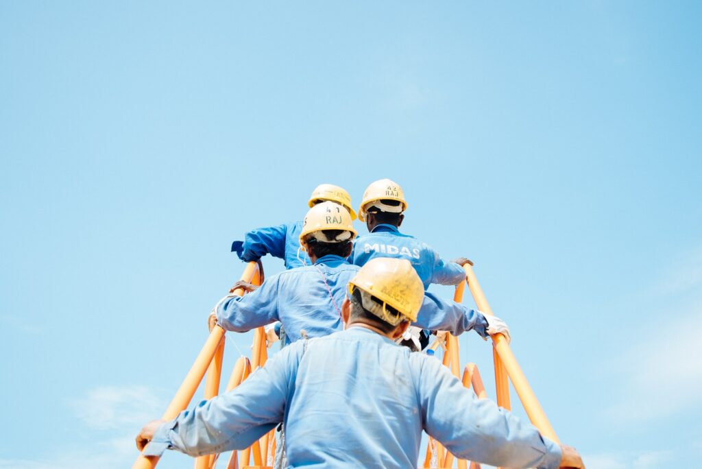 This is a photo of construction workers climbing a ladder.